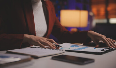 Business woman using calculator for do math finance on wooden desk in office and business working background, tax, accounting, statistics and analytic research concept