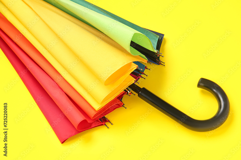Colorful stylish umbrella on yellow background