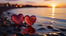 Two Glass Red Hearts On A Sandy Beach Against The Backdrop Of A Sunset At Sea. Romantic Symbol Of Love.