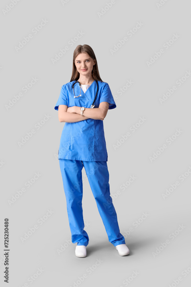 Beautiful young doctor on light background