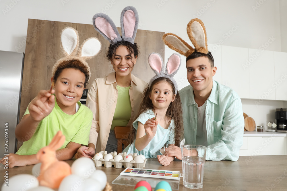 Happy family painting eggs in kitchen on Easter Day