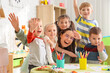 © Pixel-Shot - Cute little children hugging nursery teacher in kindergarten