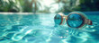 © taniasv - Swimming goggles lay in luxury exotic swimming pool water. Palm trees in the background and reflected in goggles. Blue and turquoise colors. Travel and tropical vacation mood banner