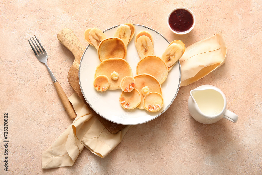 Funny Easter bunny pancakes with milk and jam on beige background