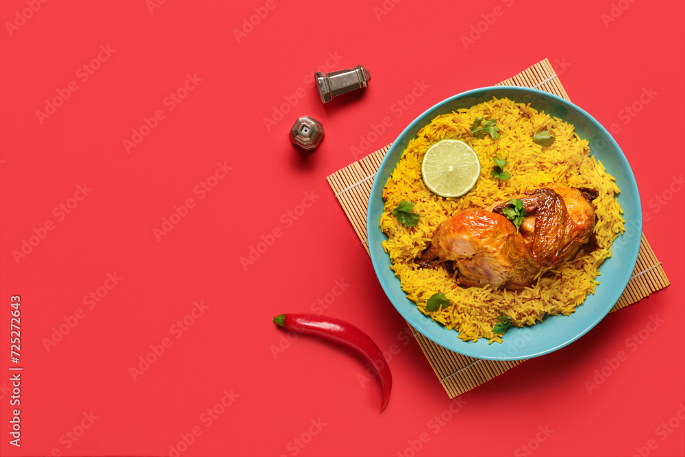 Bowl of traditional chicken biryani on red background