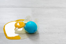 Closeup View Of Broken Easter Blue Egg With The Leaked Yolk On The Floor