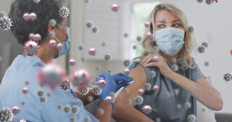 Sticker - Image of covid 19 cells over woman receiving vaccination wearing face mask