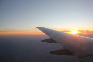 Wall Mural - Wing of an airplane in the sunset