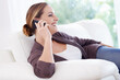 © Nicola Katie/peopleimages.com - Woman, smile and relax on sofa for phone call, communication and mobile networking at home. Happy lady, smartphone and thinking of audio contact, funny conversation and gossip for digital connection