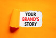 © Dzmitry - Branding and your brand story symbol. Concept words Your brands story on beautiful white paper. Beautiful orange paper background. Business branding your brand story concept. Copy space.