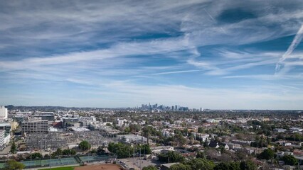 Fototapete - Aerial view of chemtrails contrail clouds over city of Los Angeles at daytime. Hyperlapse timelapse.