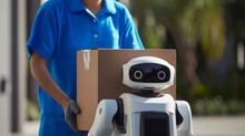 A Man In A Blue Shirt Is Holding A Box With A Robot On It, Indicating Security Robots Delivery, Service Robots, Or Machines And Robots Running In A Marathon.