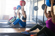 © Wavebreak Media - Multiracial women raising arms with fitness balls while sitting on floor in health club, copy space