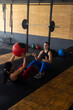 © Wavebreak Media - Diverse young women throwing fitness ball to each other while sitting on floor in health club