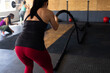 © Wavebreak Media - Rear view of caucasian young woman training with battle rope in health club, copy space