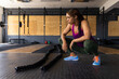 © Wavebreak Media - Tired biracial young woman crouching by battle ropes on floor in health club, copy space