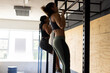© Wavebreak Media - Side view of caucasian young women practicing chin-ups on gymnastics bar in health club, copy space