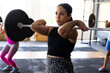 © Wavebreak Media - Dedicated caucasian young woman lifting barbell while standing in health club, copy space