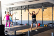 © Wavebreak Media - Multiracial young females lifting barbells while standing in health club, copy space