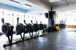 © Wavebreak Media - Empty elliptical trainer machines arranged in a row against window in health club, copy space