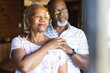 © Wavebreak Media - Thoughtful senior african american couple embracing and looking out window at home