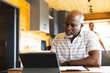 © Wavebreak Media - Senior african american man doing paperwork using tablet at home