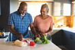 © Wavebreak Media - Happy senior african american couple unpacking groceries in kitchen