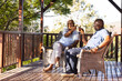 © Wavebreak Media - Happy senior african american couple drinking wine on sunny terrace