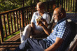 © Wavebreak Media - Happy senior african american couple drinking wine on sunny terrace
