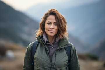 portrait of a beautiful woman hiker with backpack in the mountains