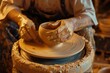 potter shaping pottery on a wheel with clay splatters