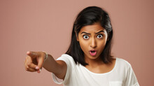 Close Up Portrait Of A Young Indian Woman Pointing At Camera Over Pink Background