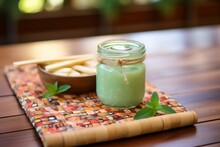 Peppermint Foot Cream In A Green Glass Jar On A Bamboo Trivet