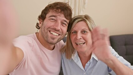 Sticker - Happy mother and son enjoy fun video call together from their living room sofa, building a lovely indoor family relationship