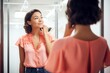 young lady in a coral top checking the neckline in the mirror of a fitting room