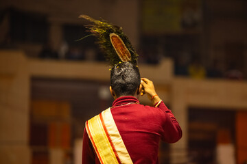 Wall Mural - Ganga aarti, Portrait of young priest performing holy river ganges evening aarti at dashashwamedh ghat in traditional dress with hindu rituals.