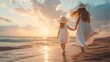 A young girl and mother in white attire and a hat stroll barefoot on the beach at sunset, with hair blowing in the wind.