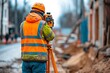 © ckybe - An employee is using a theodolite and level transit to survey distances, elevations, and directions at a construction site.