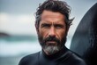 Portrait of a handsome bearded man wearing wetsuit and looking at camera