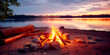 Bonfire lit by tourists on shore of picturesque lake. Hiking camping site near river. Travel and hiking camping concept in nature