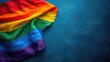 © AdriFerrer - Close-up of a rainbow flag with a blue textured background.