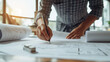 © The Stock Photo Girl - close up of architects working on blueprints