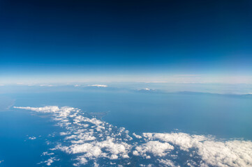 Wall Mural - view from the airplane window to mountains clouds and blue sky