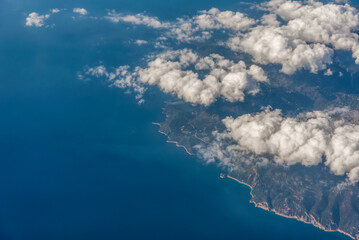 Wall Mural - view from the airplane window to mountains clouds and blue sky