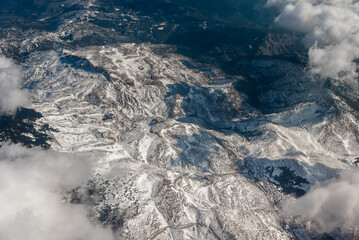 Wall Mural - view from the airplane window to mountains clouds and blue sky