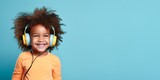 Fototapeta Młodzieżowe - Smiling curly african american kid in headphones isolated on color background.