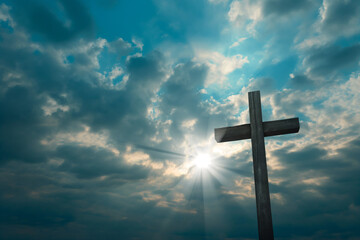 the cross rising behind a cloudy sky