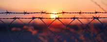 Dusk Silhouettes: Barbed Wire On Sunset. Silhouette Of Barbed Wire Against A Warm Sunset, Representing A Closed Border At Dusk.