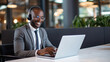 © Art AI Gallery - Smiling african american businessman in headphones using laptop in office
