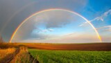 Fototapeta Tęcza - tranquil agricultural landscape with a magical rainbow at sunset ukraine europe